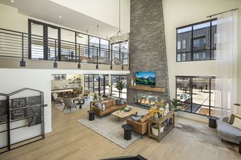 a large living room with a stone fireplace and a high ceilings